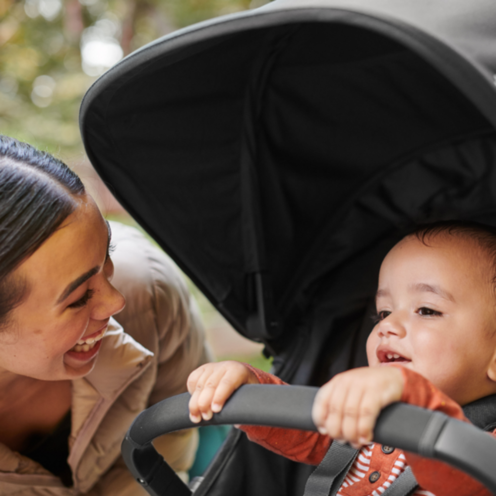 mama in otrok v vozičku se drži za ročico