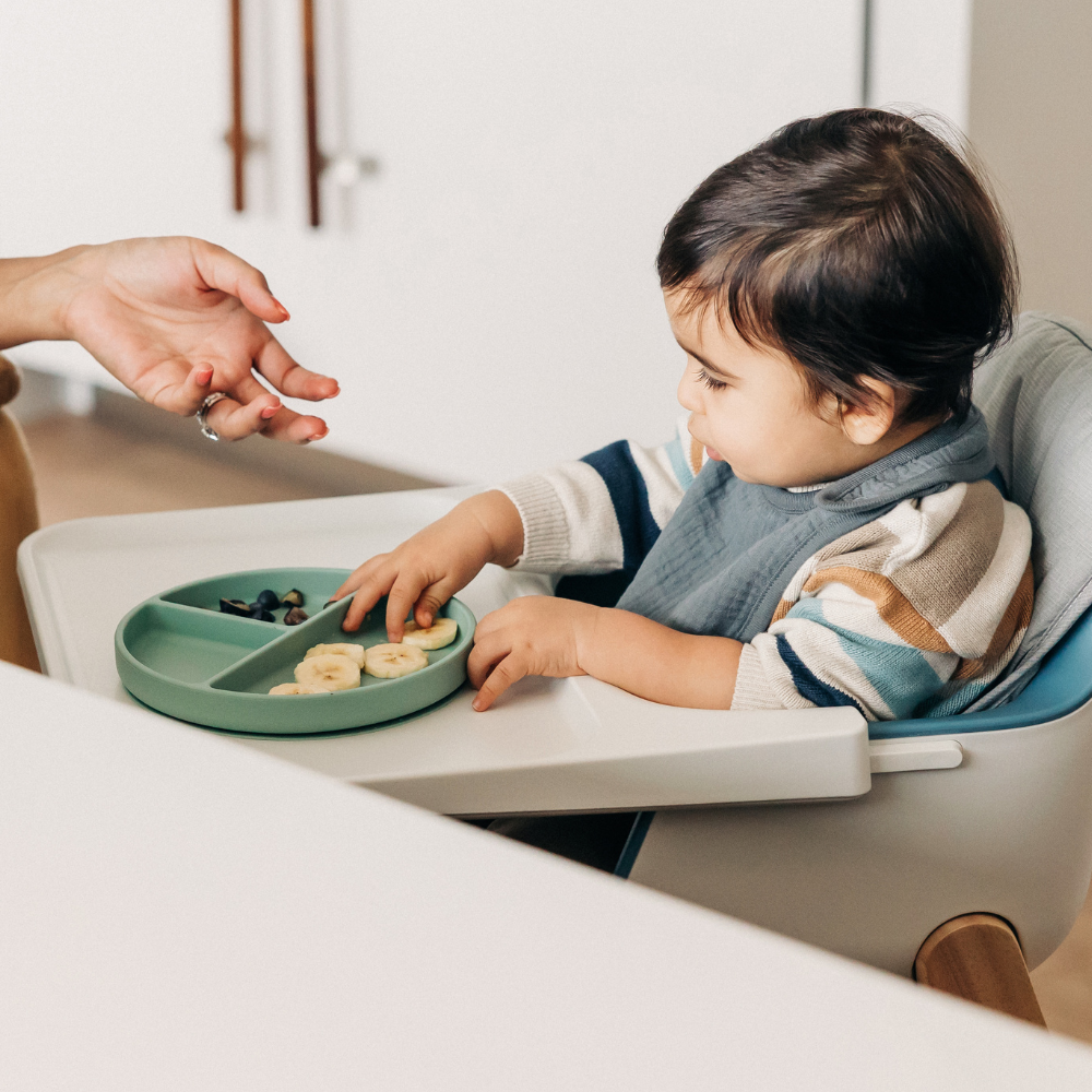 otrok na otroškem stolčku se hrani